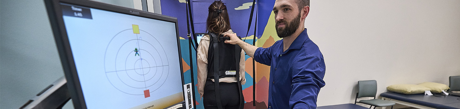 Therapist looking at computer screen while treating patient