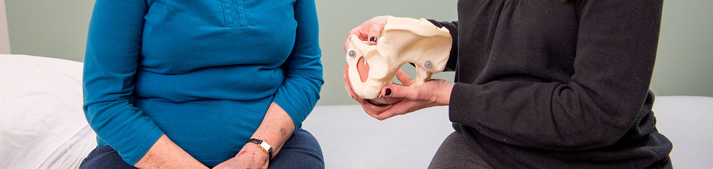 Woman pelvic floor therapist discussing treatment options with older white woman.